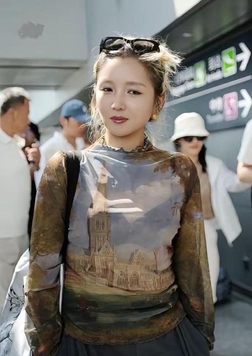 何洁现身成都，她这次的穿搭看上去格外的显年轻，气质超好。上身穿一件带有复古建筑印