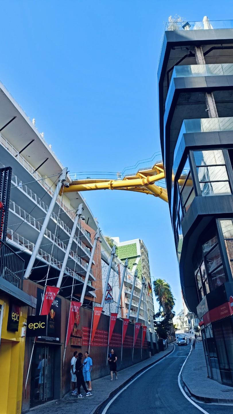 现代都市街景，高楼林立，行人漫步，阳光明媚。
上联:繁华街市闹，
下联:人间烟火