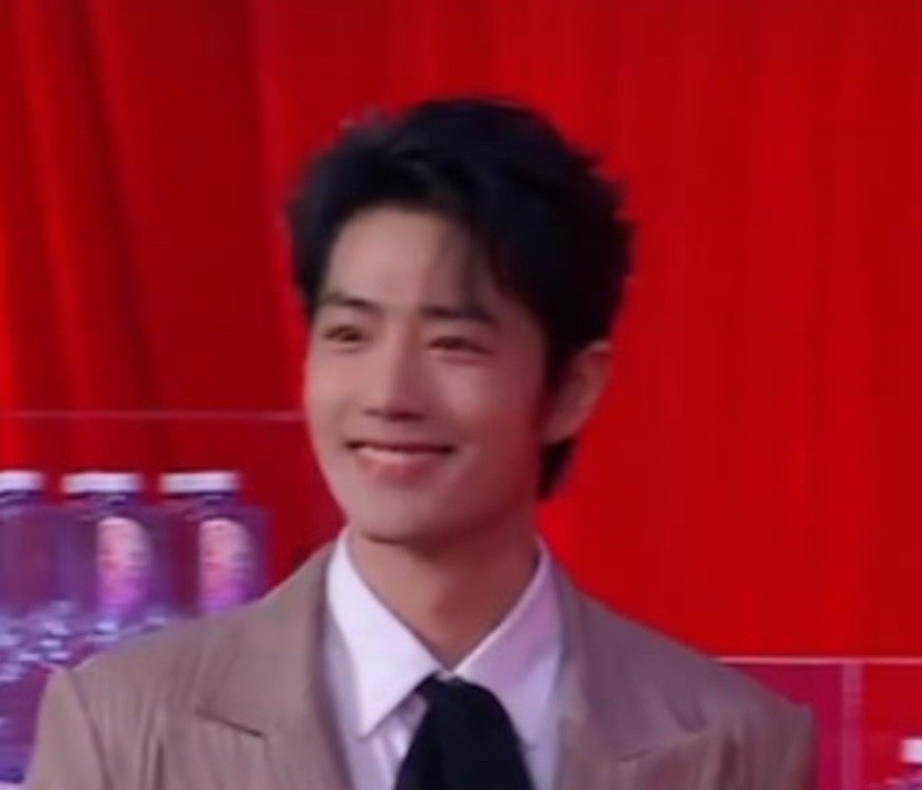 肖战这波颜值鲨疯了！🖤 黑色蝴蝶结点缀简约穿搭，在红色背景衬托下愈发俊朗。标志