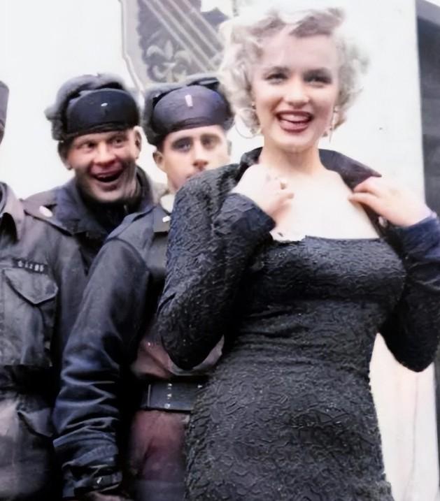 1940年，一名士兵举起一名年轻貌美的女人，将她送给卡车上的大兵，大兵见到女子不