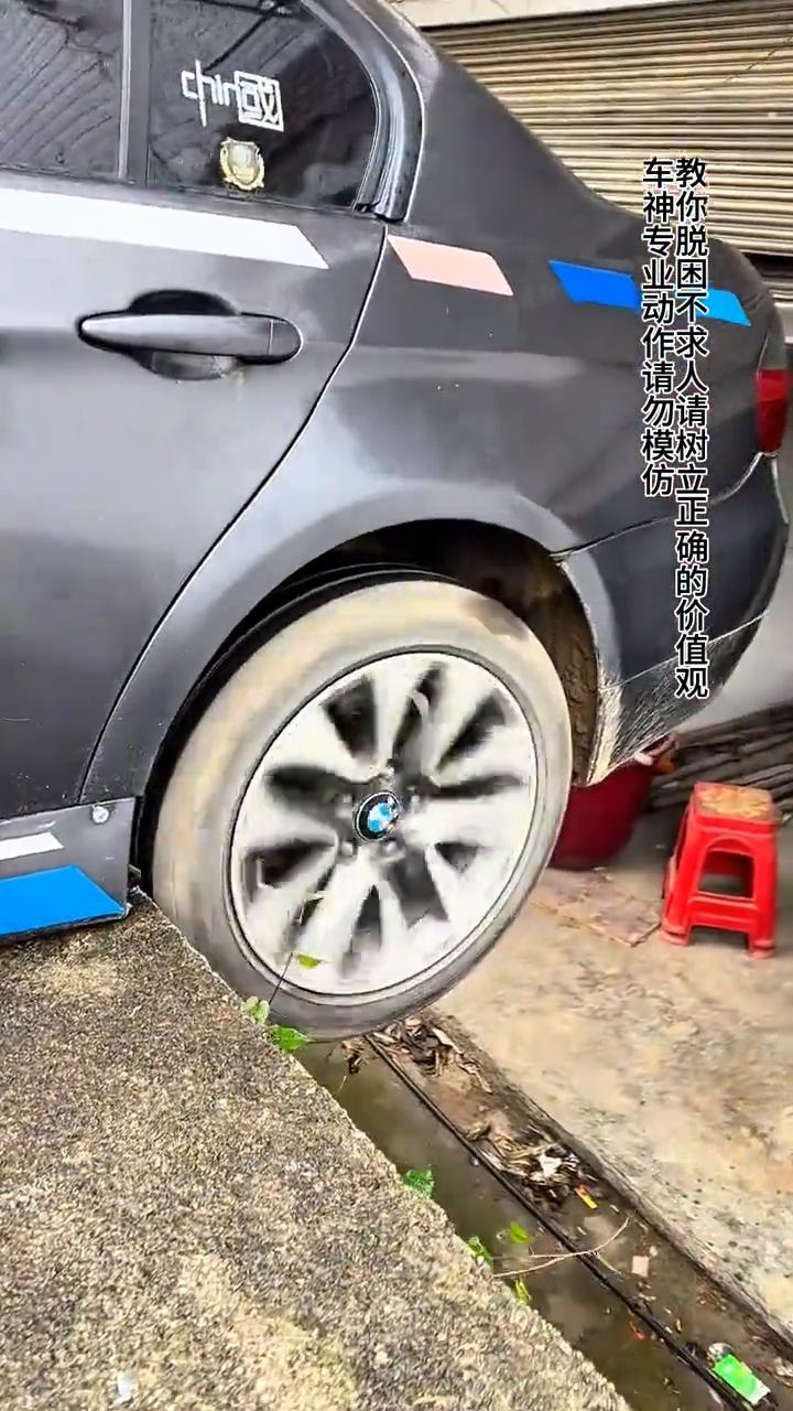 汽车一招脱困不求人。
先看汽车两个后轮同时掉下路坎，这种情况很多人都会加油往前面