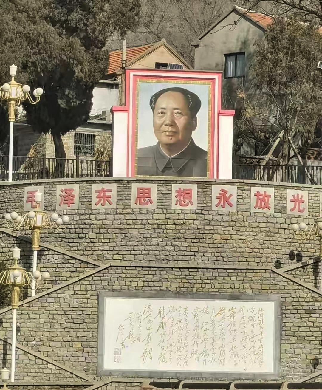 刷到一张让人心里一暖的照片，一个普通村庄里，高高挂着毛主席的巨幅画像，配着“毛泽