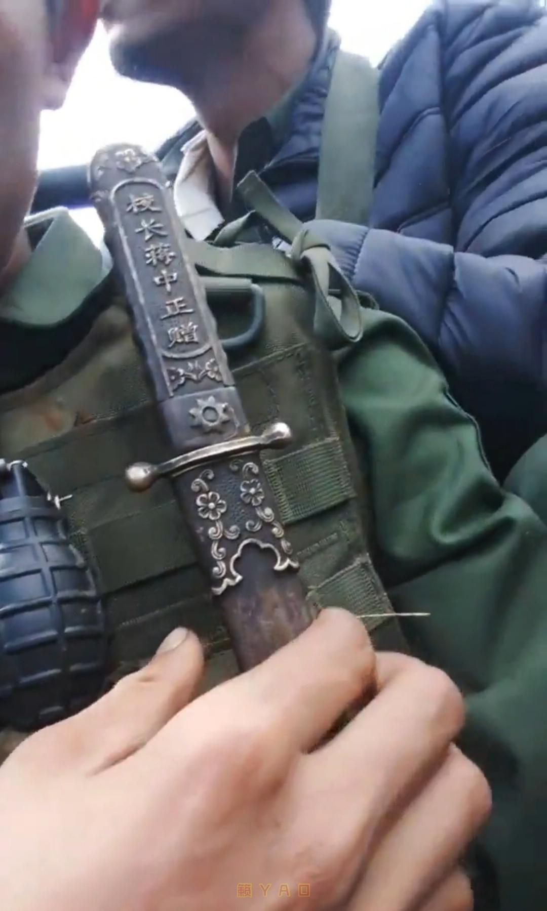 一名果敢同盟军士兵展示他的装备，随身的佩剑比较有意思，刀鞘上面用简中字体标有“校