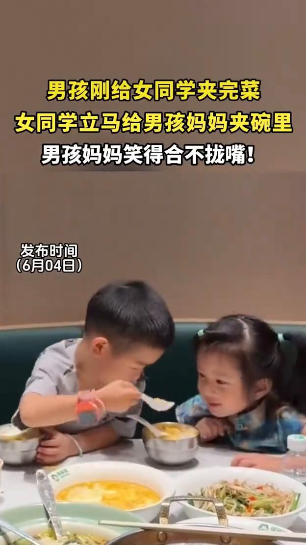 男孩刚给女同学夹完菜，女同学立马给男孩妈妈夹碗里，男孩妈妈笑得合不拢嘴。
发布时