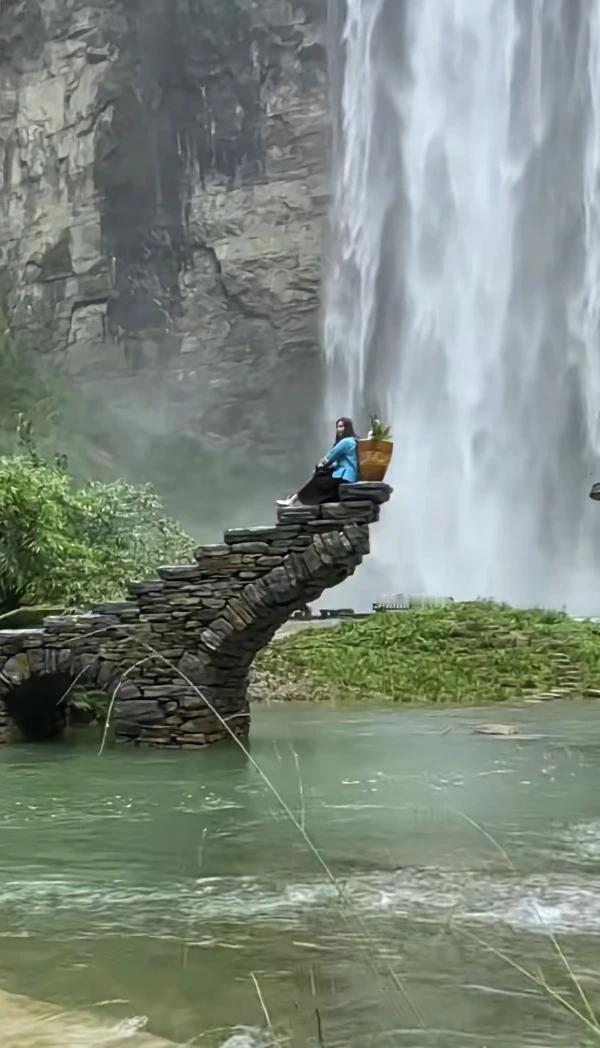瀑布落下砸个坑，
坑边残桥有风景。
采药女子桥顶坐，
静听流水有妙音。