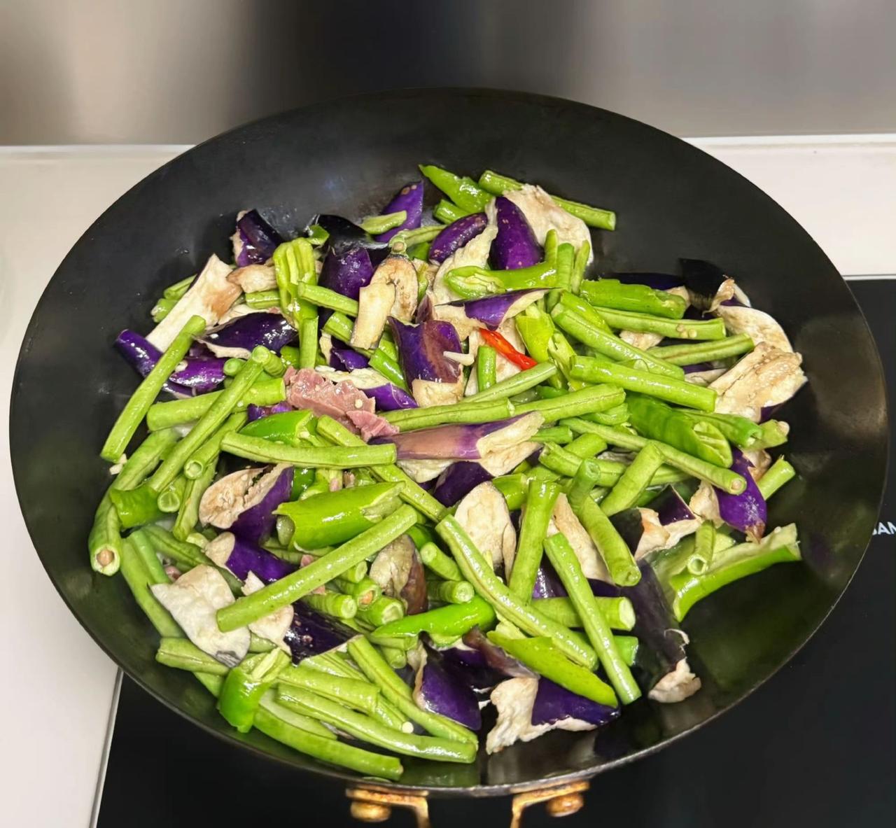 🍳锅气裹着紫茄绿椒跳圆舞曲💃，咸香渗进每寸肌理。烟火人间，不过一炒勺的温柔。