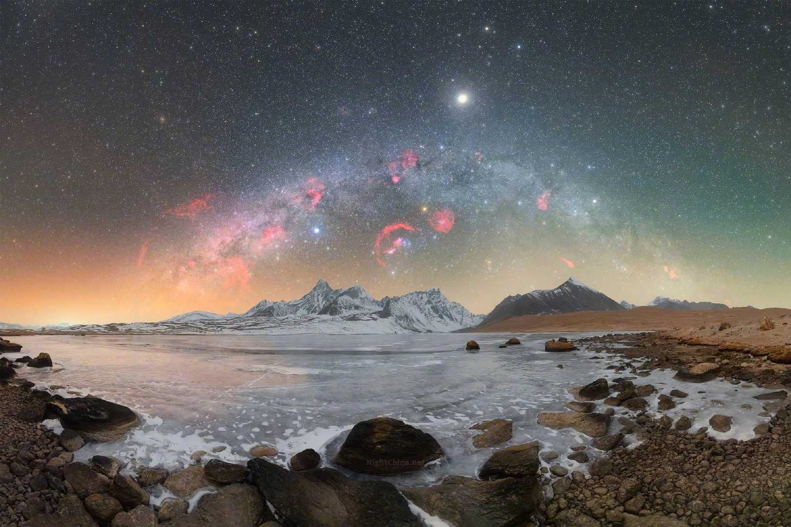 冬季银河将自己弯成一道光之拱门，横亘在雪峰与冰湖之间。那些在天穹深处燃着暗红的星