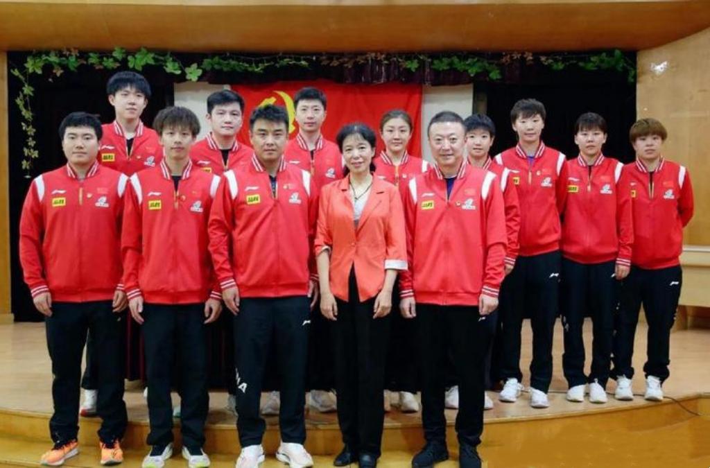 这张国乒成员在党旗前的大合照：

我认出了功勋教练王皓、马琳；还认出了奥运冠军陈