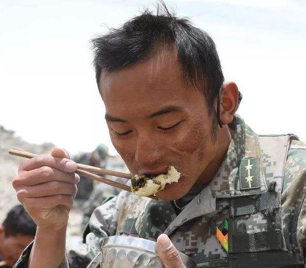 这是一位正在吃饭的解放军战士，他的职责是守卫边疆，看着他饱受风吹日晒的脸庞，真的
