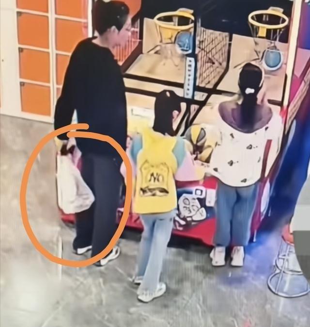 游乐场监控拍到宝妈带俩娃偷篮球，先假装玩球，然后用塑料袋装走还盖外套遮掩，太离谱