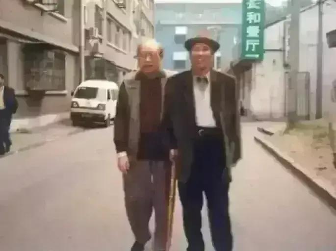 1990年的一天，北京的一条背街小巷里发生了这样一幕，两位老人在遛弯时不期而遇，