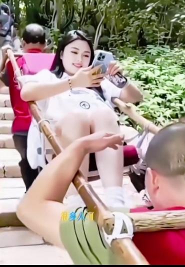 这个坐轿上山的女子、应该是故意博眼球
上山坐轿都是脚前头后、这种姿势才舒服，这个