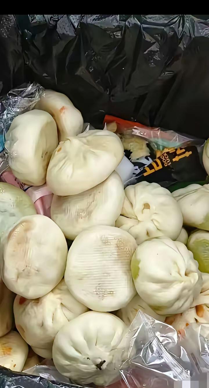 这是一位网友在其所住小区垃圾桶里拍到的：一大袋子暄软的包子，就这样被人扔在里面了