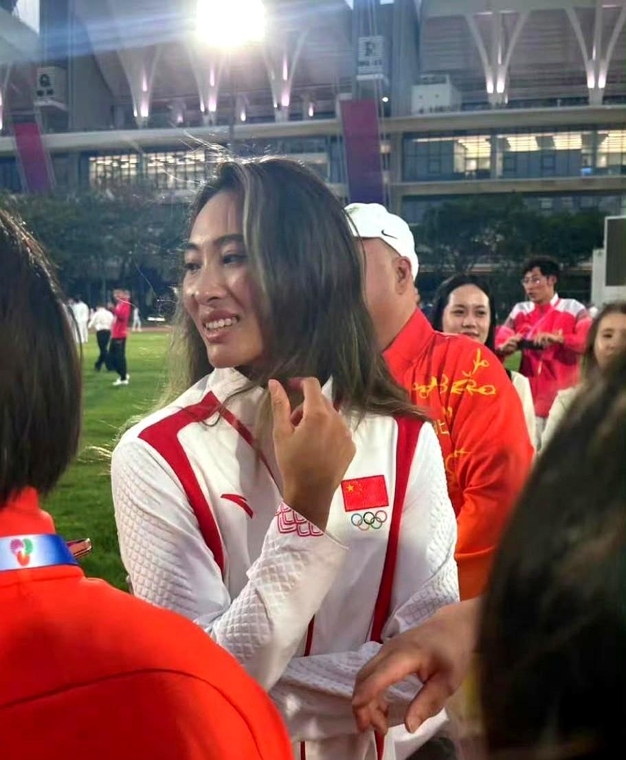 旗手郑钦文一抬手，全场先盯的不是金牌，是她头上那几撮跳染——蓝灰挑在黑发里，像把