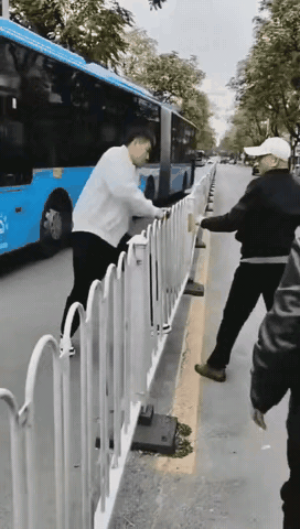 小伙子要横跨护栏，两路过的大爷不干了，坚决不让，恼羞成怒的小伙子挥拳猛击，再次试