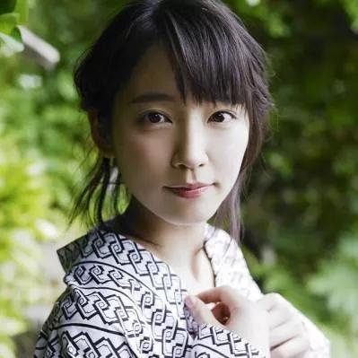 在绿意盎然的背景中，她温柔地微笑，散发着自然的美。