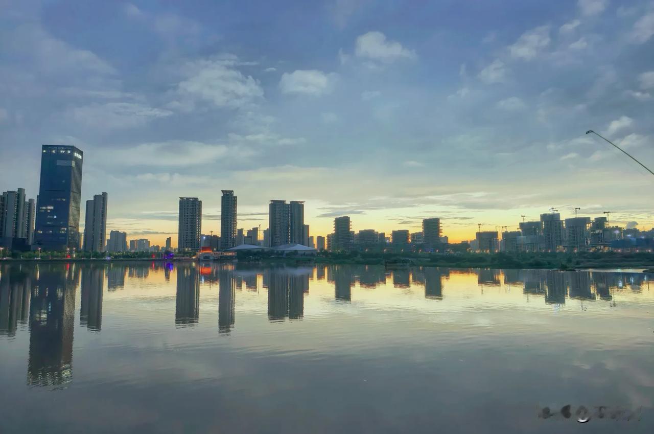 落日悄悄地藏在楼宇后面，整座城市的剪影都晕在水里，连风都放慢了脚步。