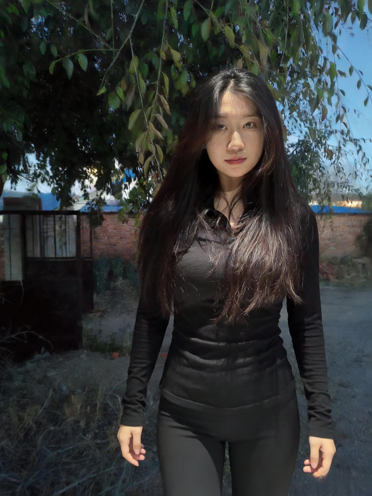 黑衣漫卷秋风里，长发斜簪野树旁。
抬眼遥看云影阔，一身清寂立斜阳。