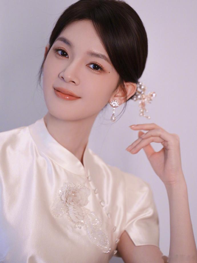 陈瑶素色旗袍拍出东方诗意陈瑶国风九宫格写真氛围感拉满，顺滑米白缎面旗袍勾勒温婉身