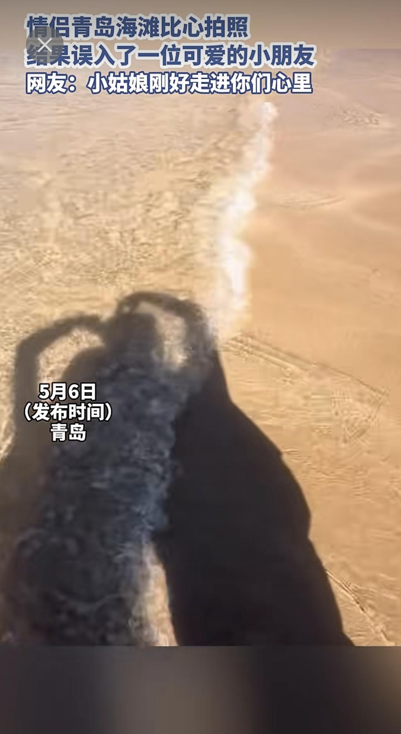 情侣青岛海滩比心拍照，结果误入了一位可爱的小朋友，网友：小姑娘刚好走进你们心里。