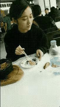 这女子一看就知道是勤俭持家的，
一块肉不小心掉到桌上，
看看没人注意就拣了起来，