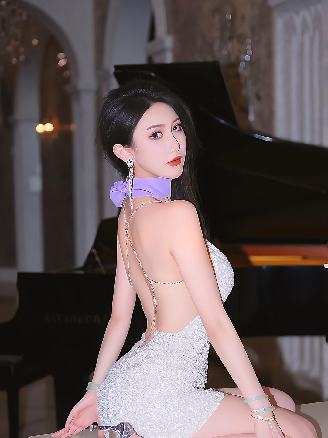 来看看这组美到心颤的写真。模特身着白色吊带短裙，紫色蝴蝶结颈饰俏皮可爱，蕾丝与露