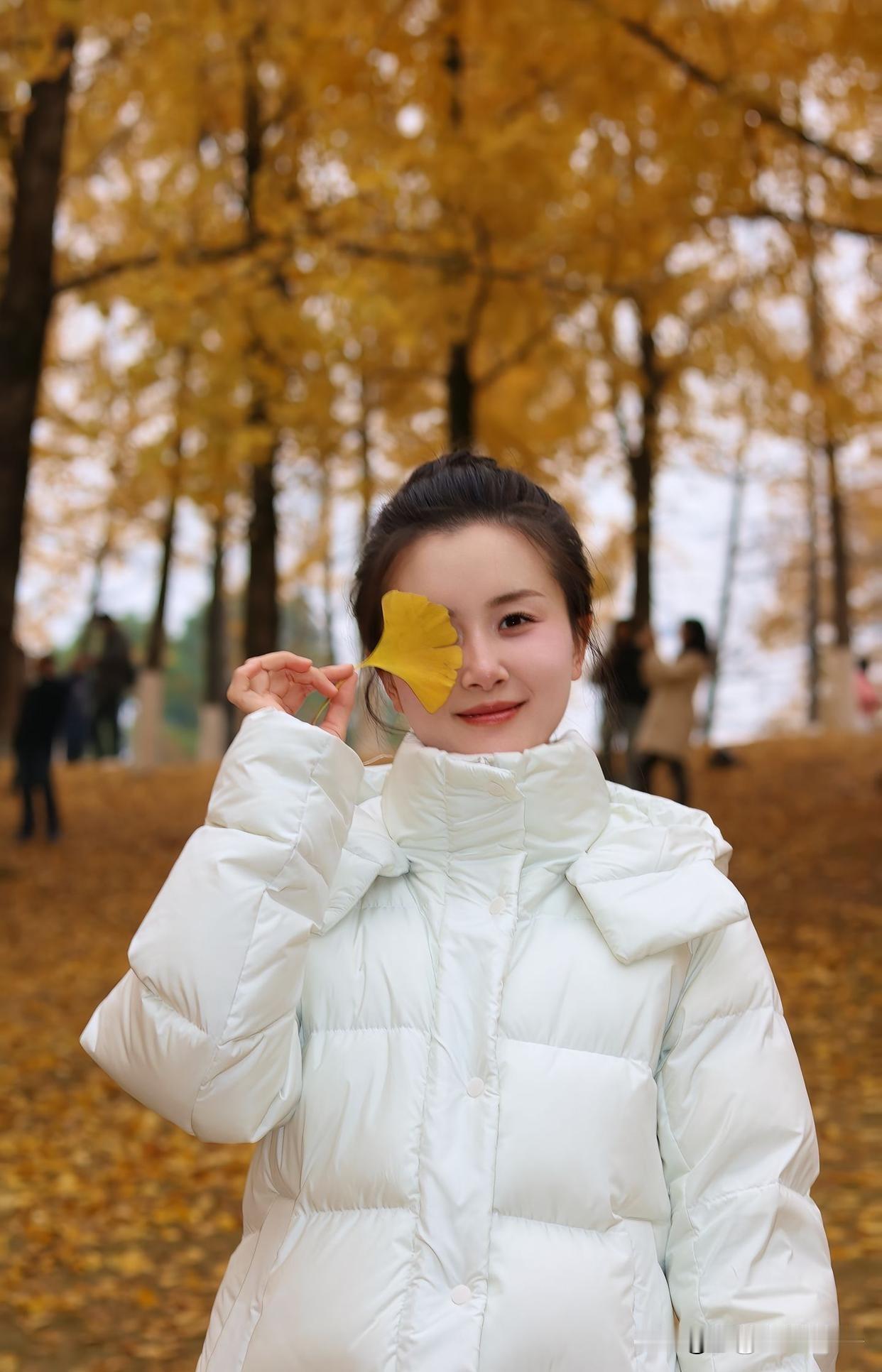 秋日暖阳，宛如一层金色薄纱，轻柔地洒在大地上。一位少女漫步在林间小道，脚下落叶沙