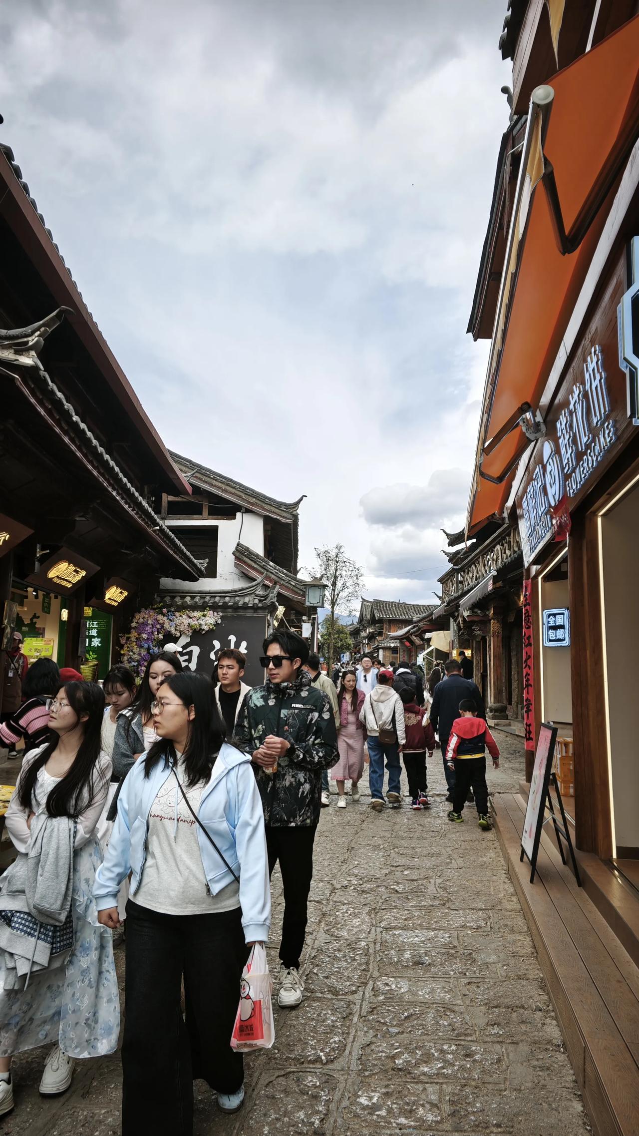 分享你的随手拍青石板路藏着岁月的回响，纳西屋檐下飘着鲜花饼的甜香，人潮涌动里，是