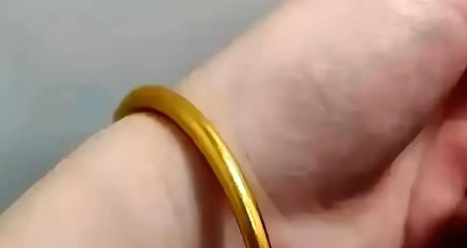 一女子在夜市花10块钱买了个镀金镯子，戴了八年都没没掉色，去金店清洗，师傅拿着放