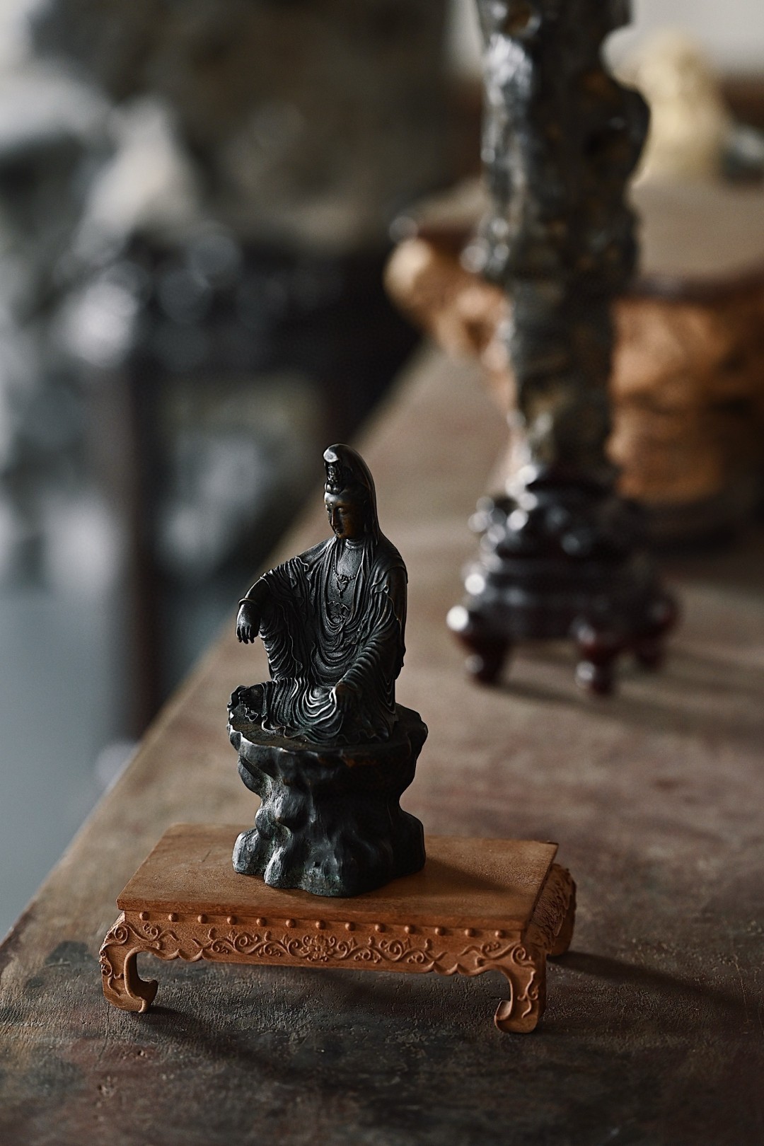 铜 | 自在观音观音低首垂目，开脸饱满丰润，神情慈祥，头戴风帽自在而坐，衣纹垂拂