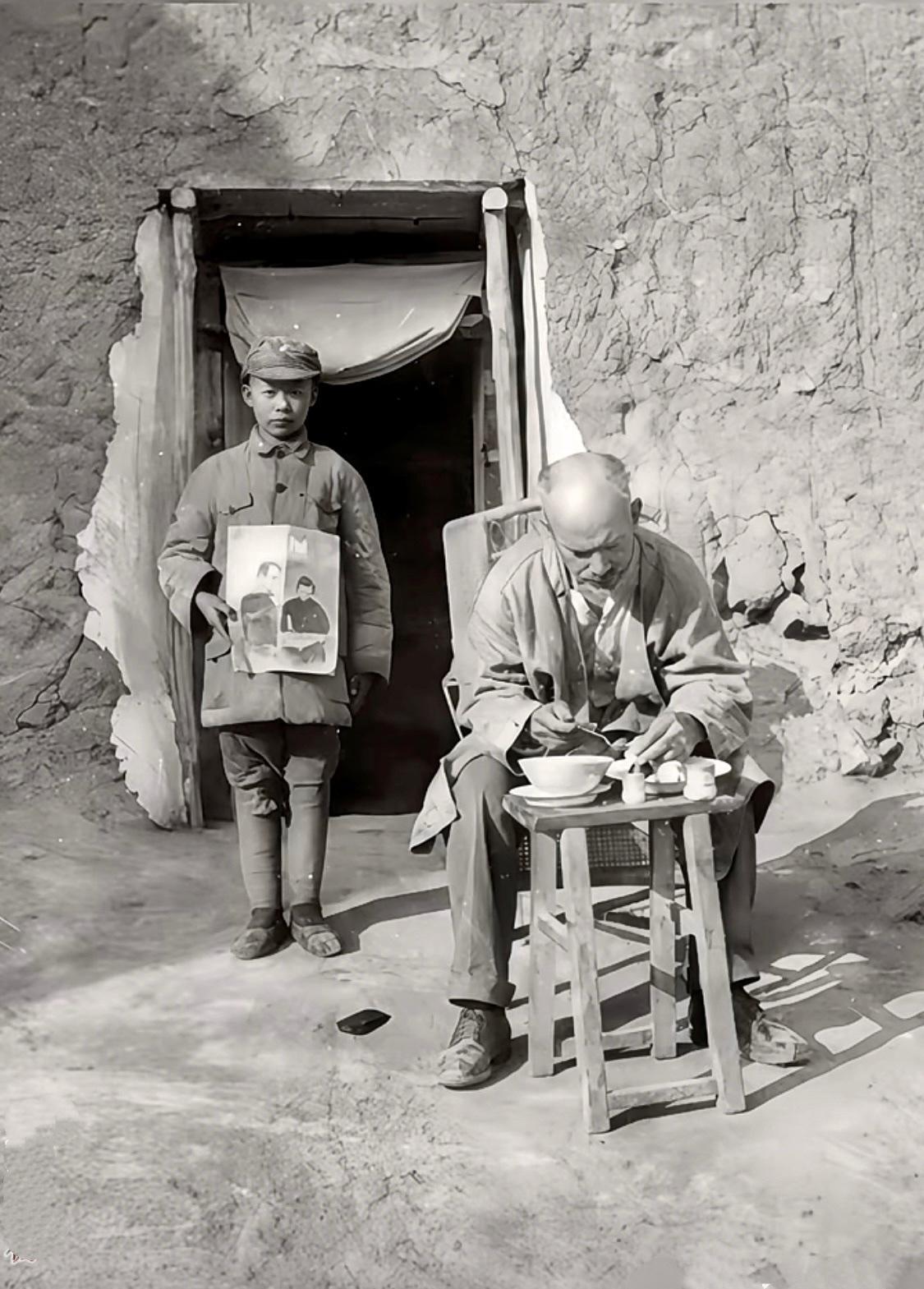 这张由著名战地记者沙飞拍摄的照片里，加拿大医生白求恩正坐在土坯房前吃着简单的“特