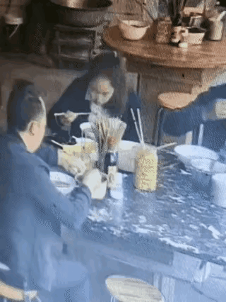 男的在饭店吃完饭，把半碗辣椒油倒进自己的碗里，然后用筷子搅合搅合，转身用餐巾纸擦