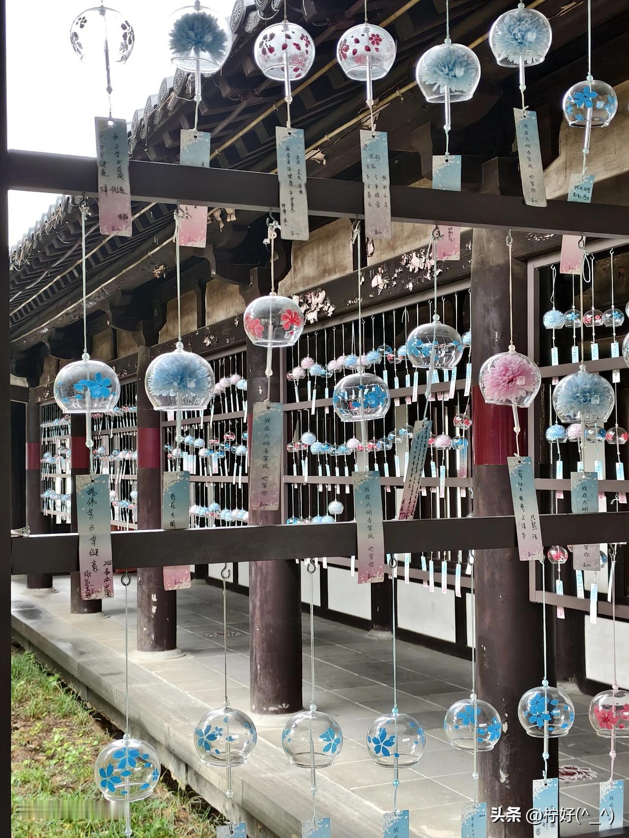 这张照片，是我去年在扬州大明寺拍下的。
寺内一边的屋檐下悬着一串串风铃，透明的球