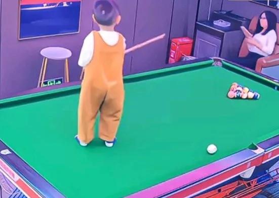 家长将孩子独自放在台球桌上玩，她坐到椅子上玩手机，了孩子被桌边绊倒，
直接摔到地