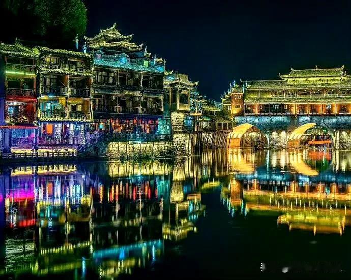 夜幕降临，凤凰古城换上华服，灯火逐次亮起，瞬间变身光与影的梦幻之境。飞檐斗拱、木