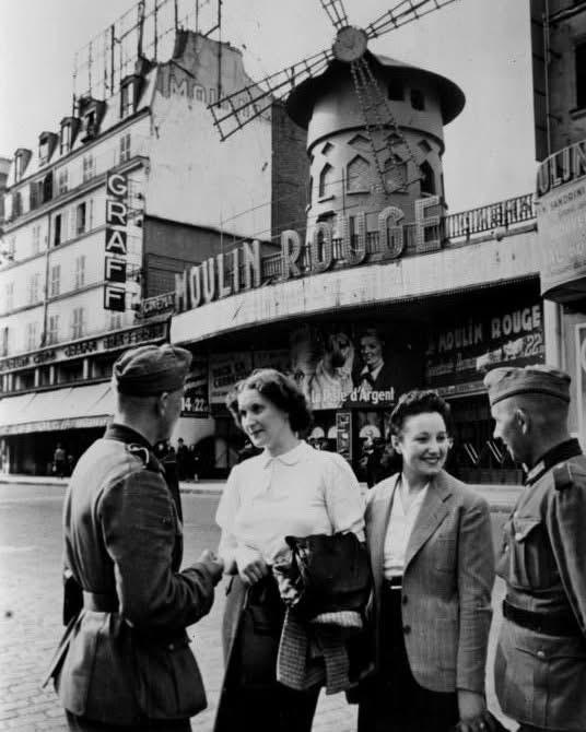 1940年6月，法国沦陷初期，德军士兵在红磨坊外与法国的当地女性交谈！后续盟军解