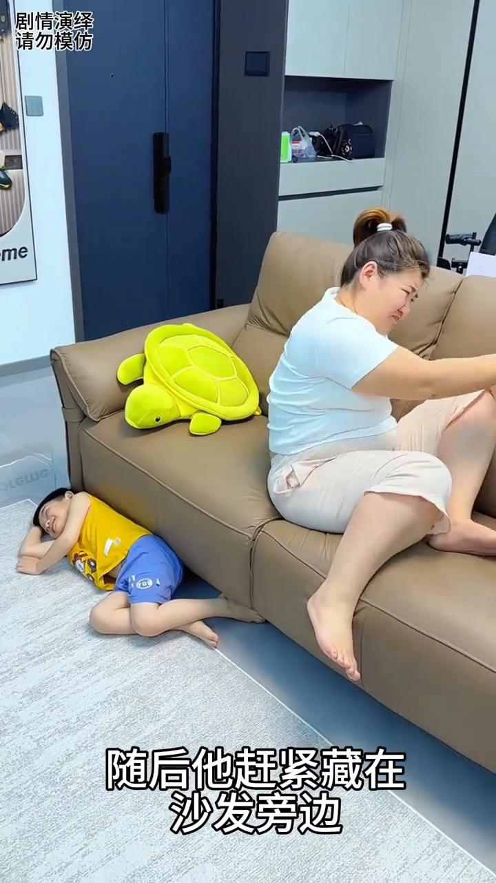 妈妈躺在沙发上休息，这时淘气的男孩把鞋子放妈妈嘴上，随后他赶紧藏在沙发旁边。妈妈