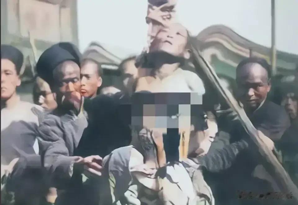1905年一个被凌迟处死的女犯人场面，她被绑在木桩上，而且衣服也被扒了下来，正被