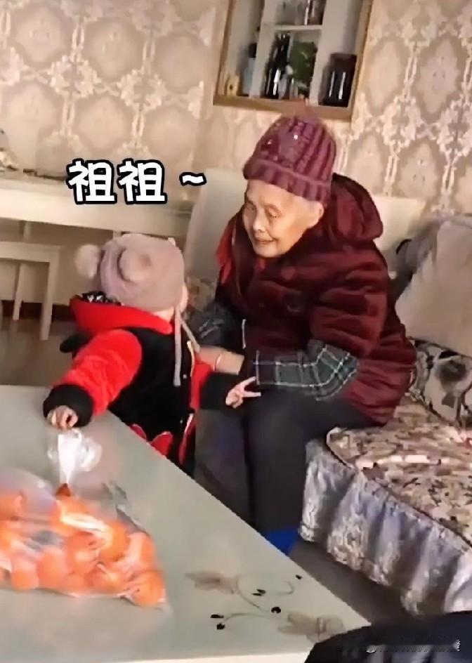 老人正在看电视，宝宝慢慢走到她身边，并抬头看着她，冷不丁开口喊了一句“祖祖”，老