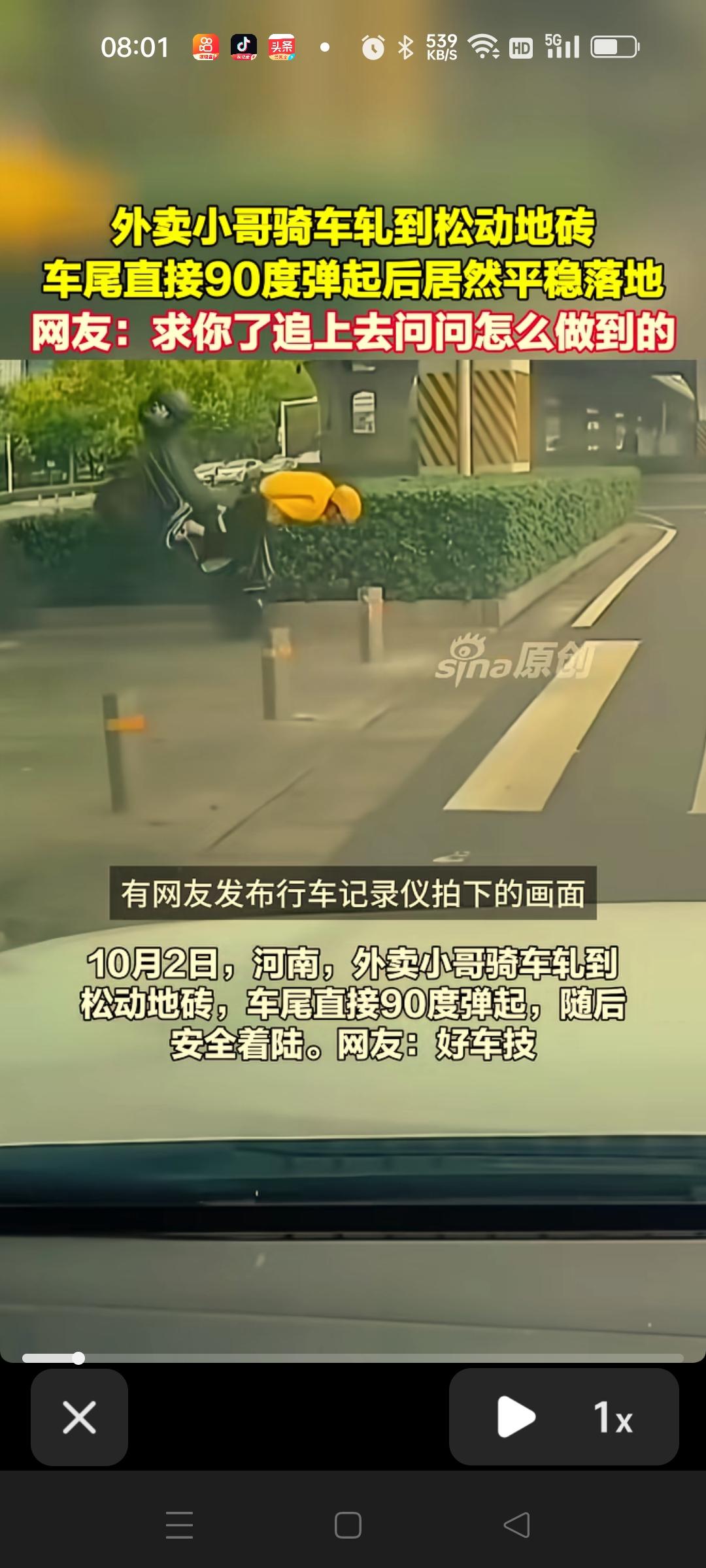 一名外卖小哥骑车车子压到松动的地砖，前轮突然直挺挺的立起来，还向前滑去差不多将近