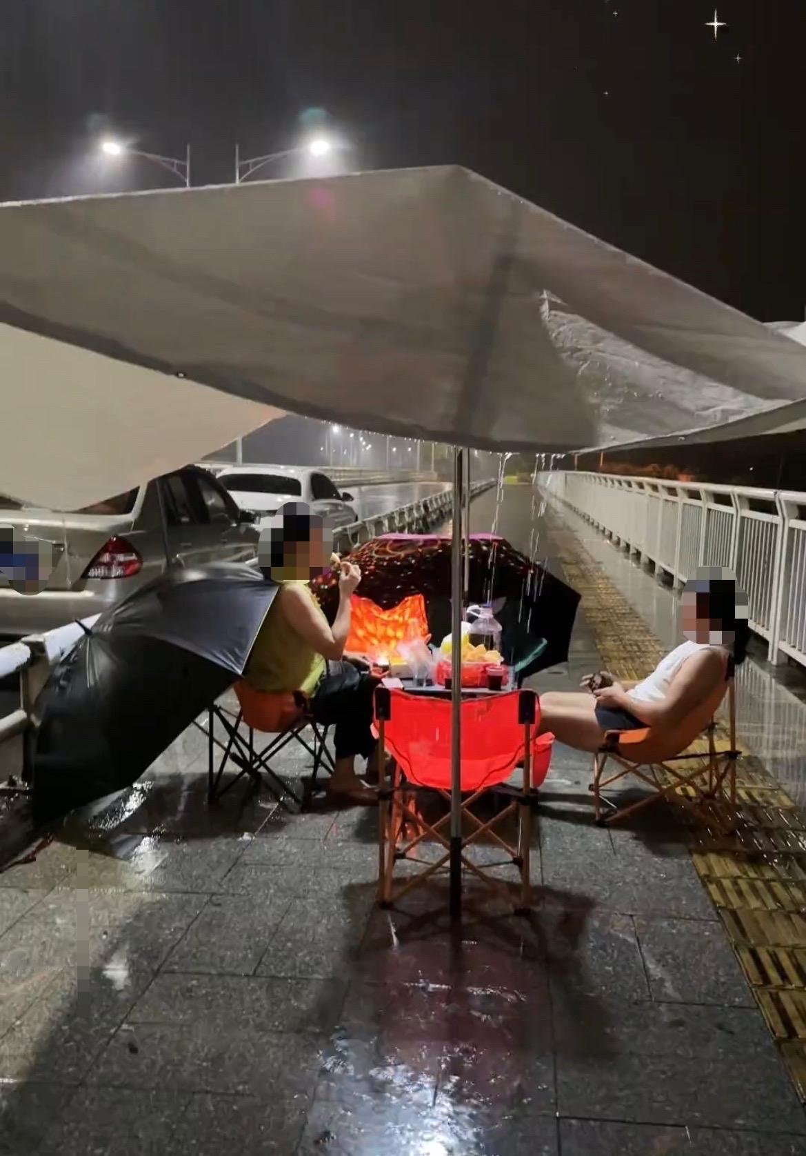【玉林下雨天二环西路多名女子撑伞野餐】

8月30日晚，下雨天在玉林二环西路的人