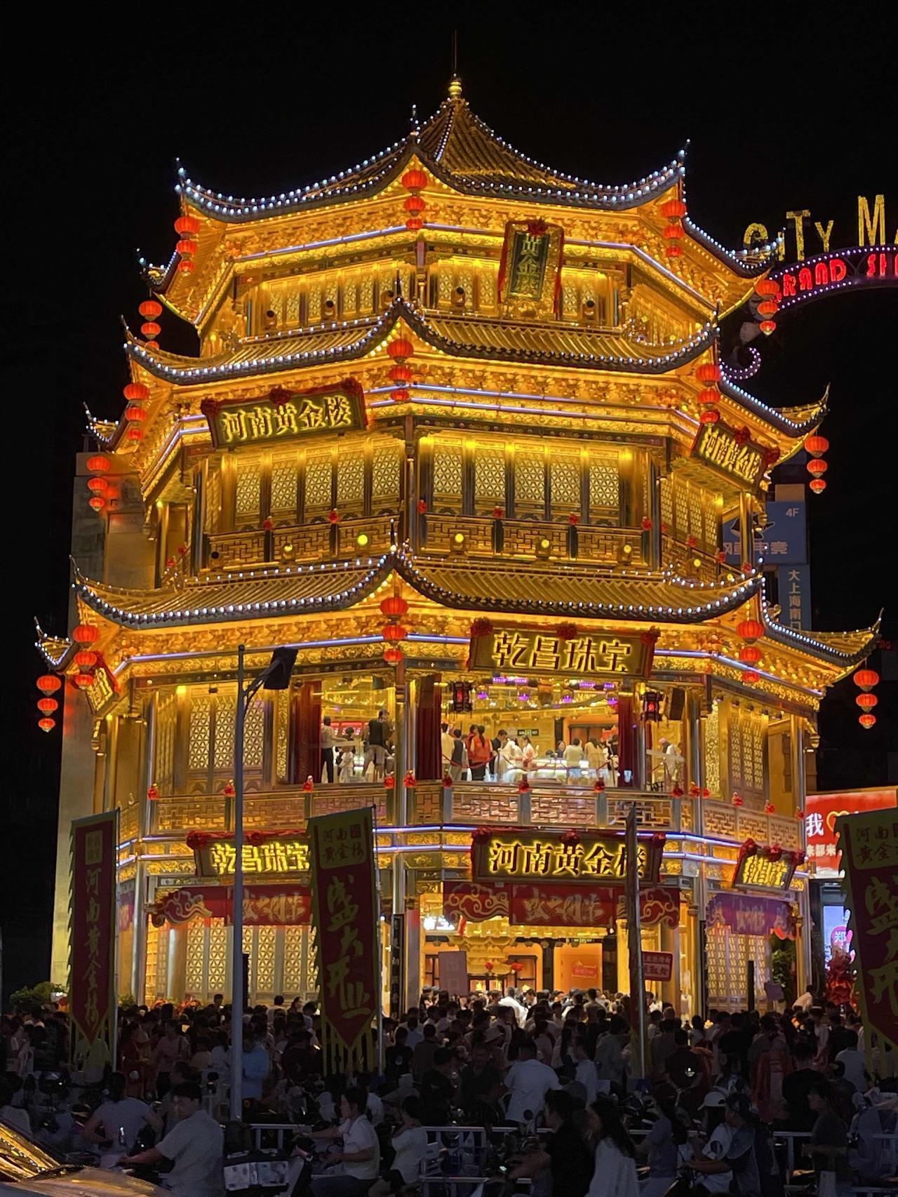 郑州二七黄金楼开业，夜晚亮灯金光闪闪，流光溢彩排队的顾客人山人海，很多人站在外面