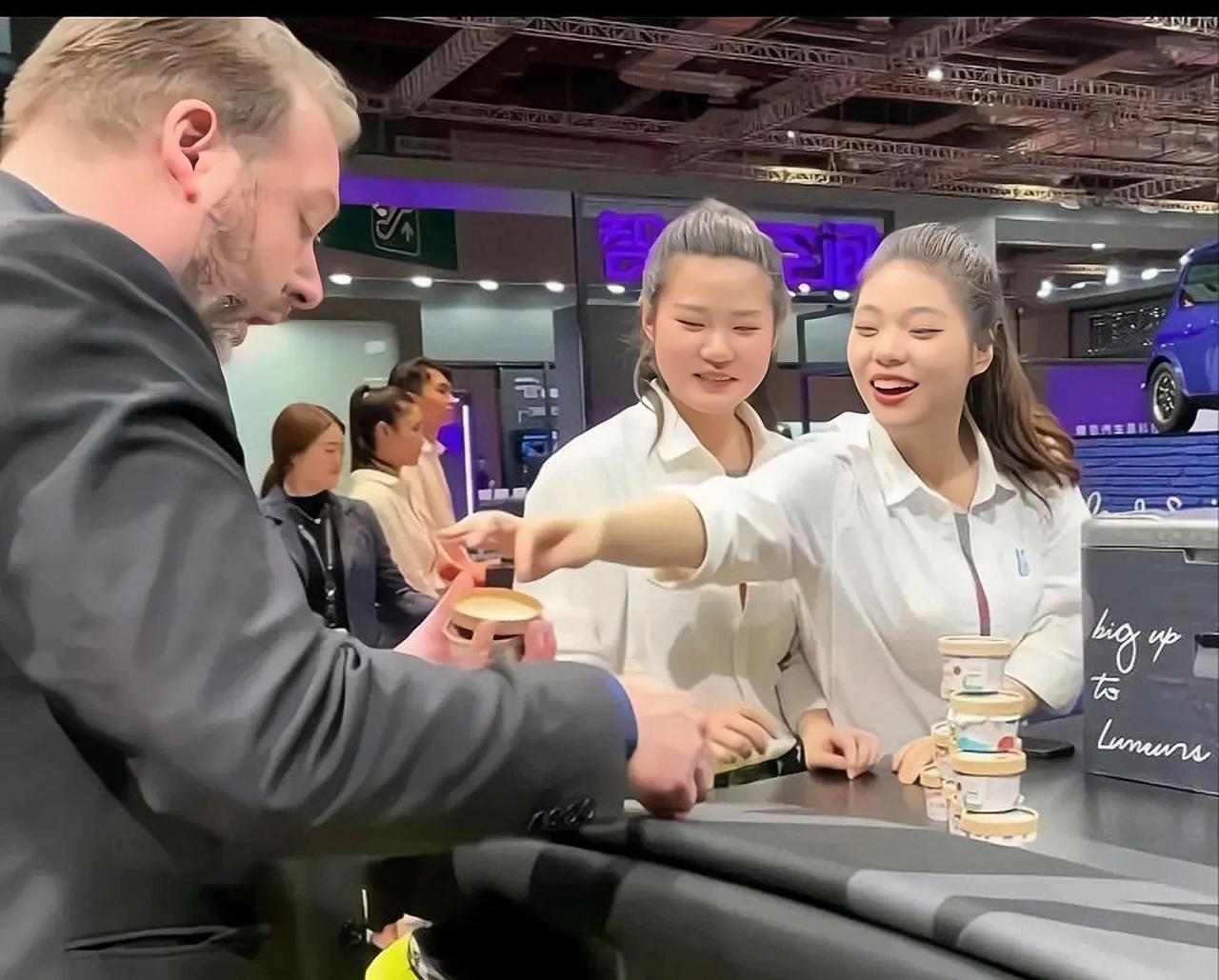 上海宝马mini车展上，两个派送冰淇淋的“变色龙”小姐姐。
这俩姑娘对外国人一副