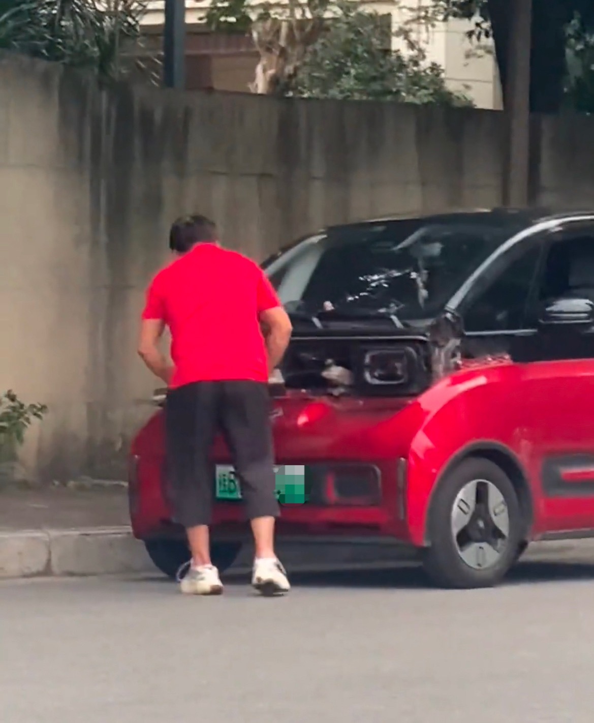 【柳州一车主直接在路边给自家小车套牌】近日，网友看见：广西柳州一名男子在路边给自