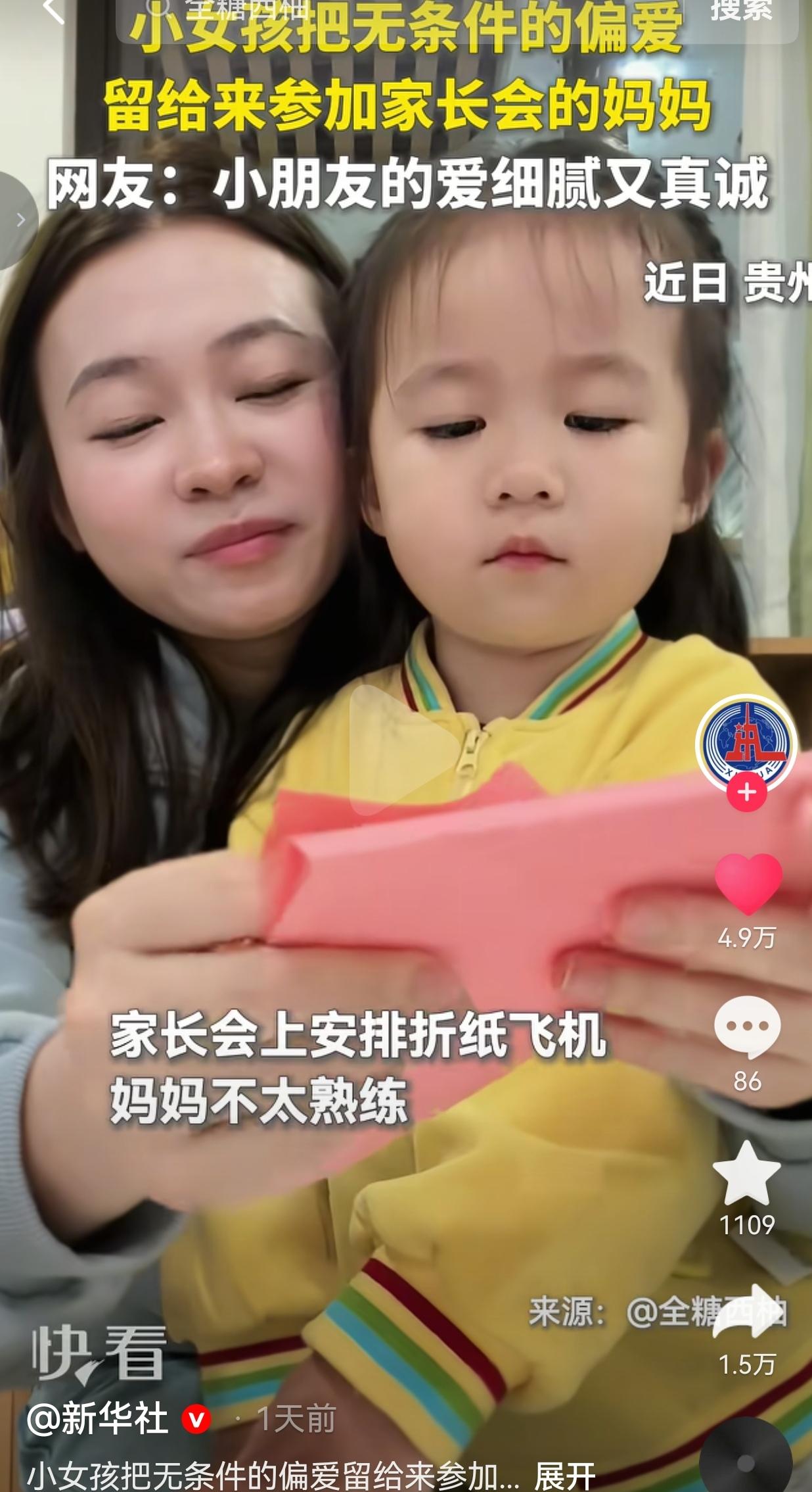 幼儿园开家长会，现场有个折纸飞机的小任务，需要家长动手一起折。视频里，妈妈拿着彩