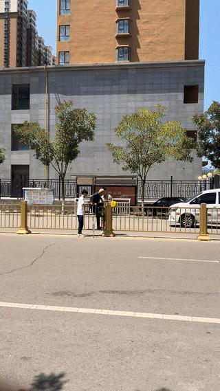 两名年轻小伙竟然站在马路中间，帮一位拄拐的老大爷翻越护栏横穿马路？
他们难道不知