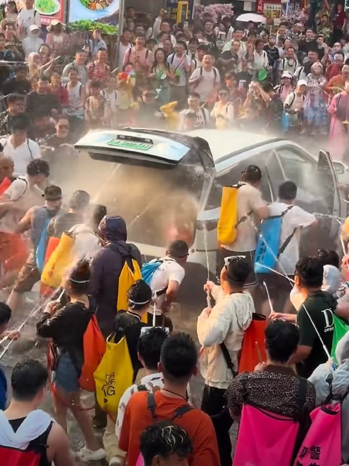 女子被强拉开车门泼水车内部冒烟 就看看这个泼水节现场的图片，你喷车的外面还可以，
