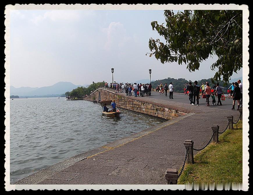 漫步西湖江南岸，一湖山水藏尽温柔人间
暖风拂过西湖堤岸，垂柳依依，湖水波光粼粼。