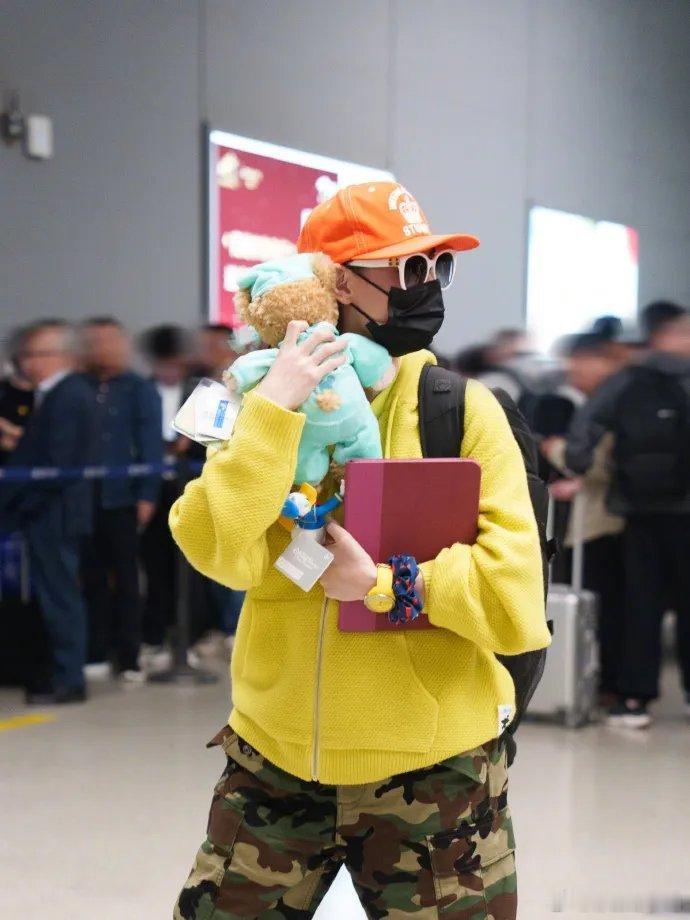 张柏芝机场私服随性又时髦。内搭柠檬黄T恤，外搭同色系连帽卫衣，叠穿层次感十足下身