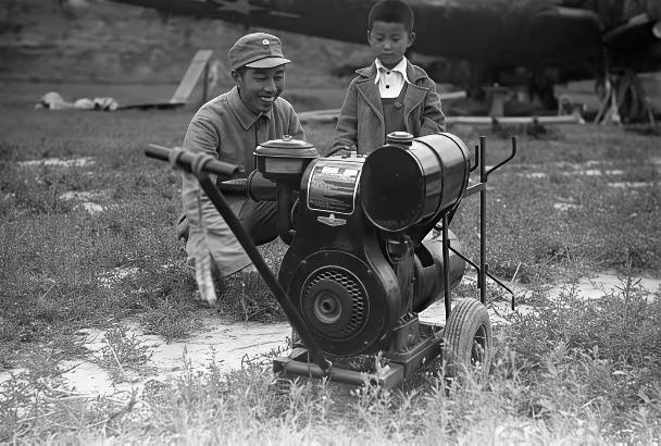 1944年，延安，机器的左侧是王震将军，他一身简朴的八路军军装，露着大白牙，脸上